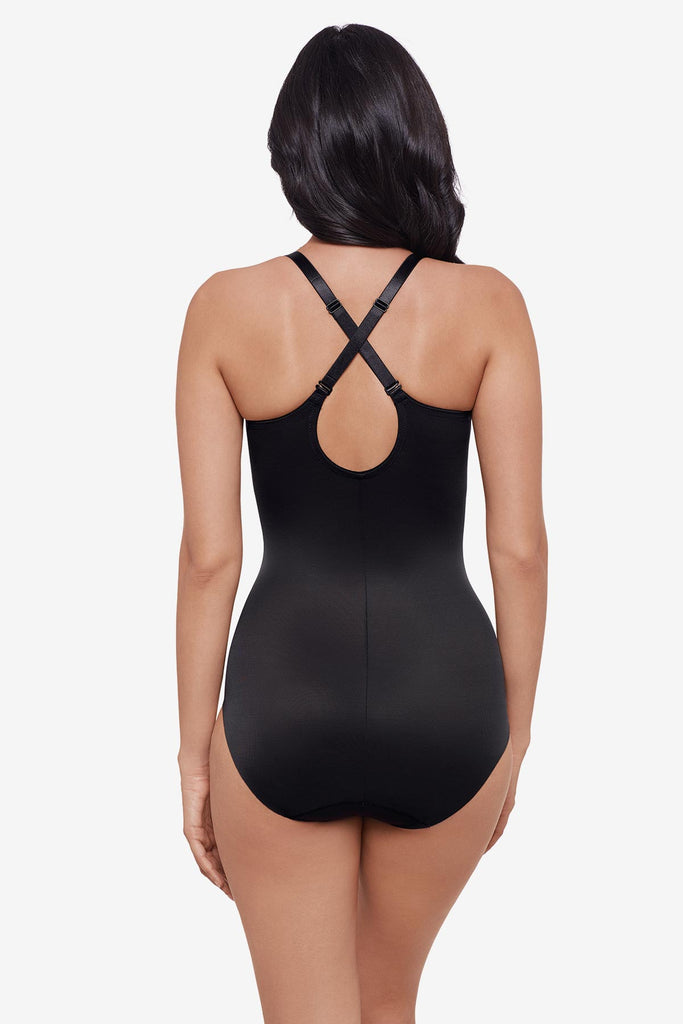 Woman wearing an X back black one-piece shapewear