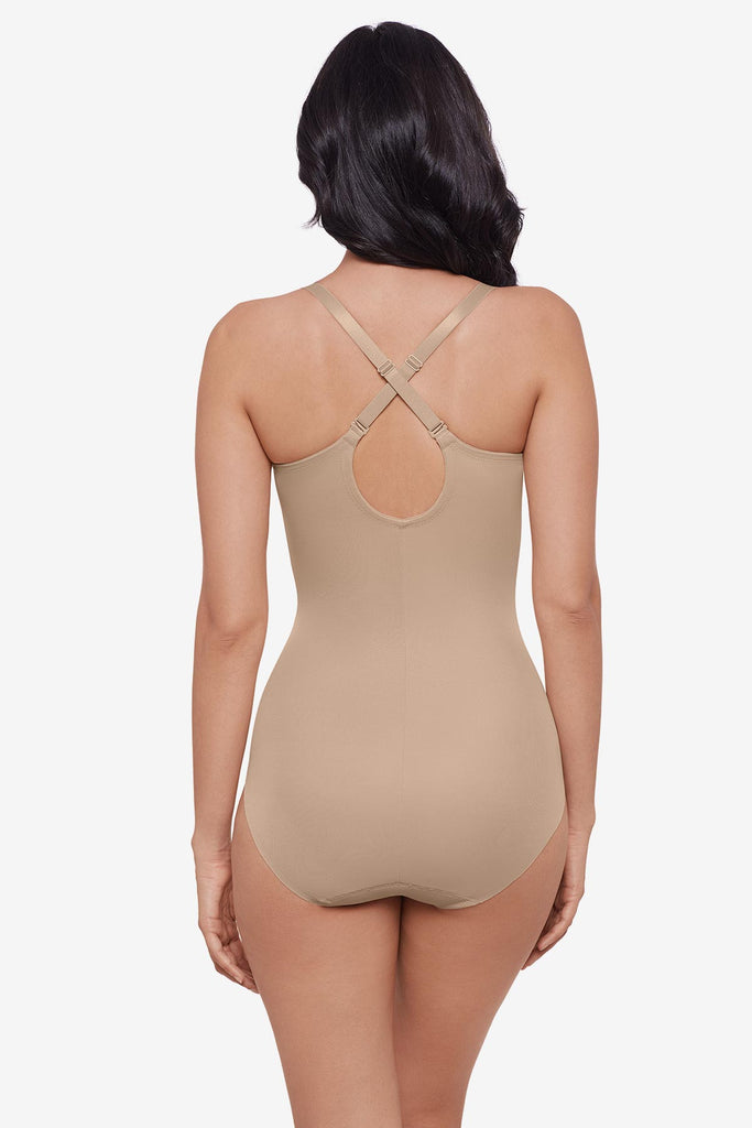 Woman faced away wearing warm beige one-piece shapewear