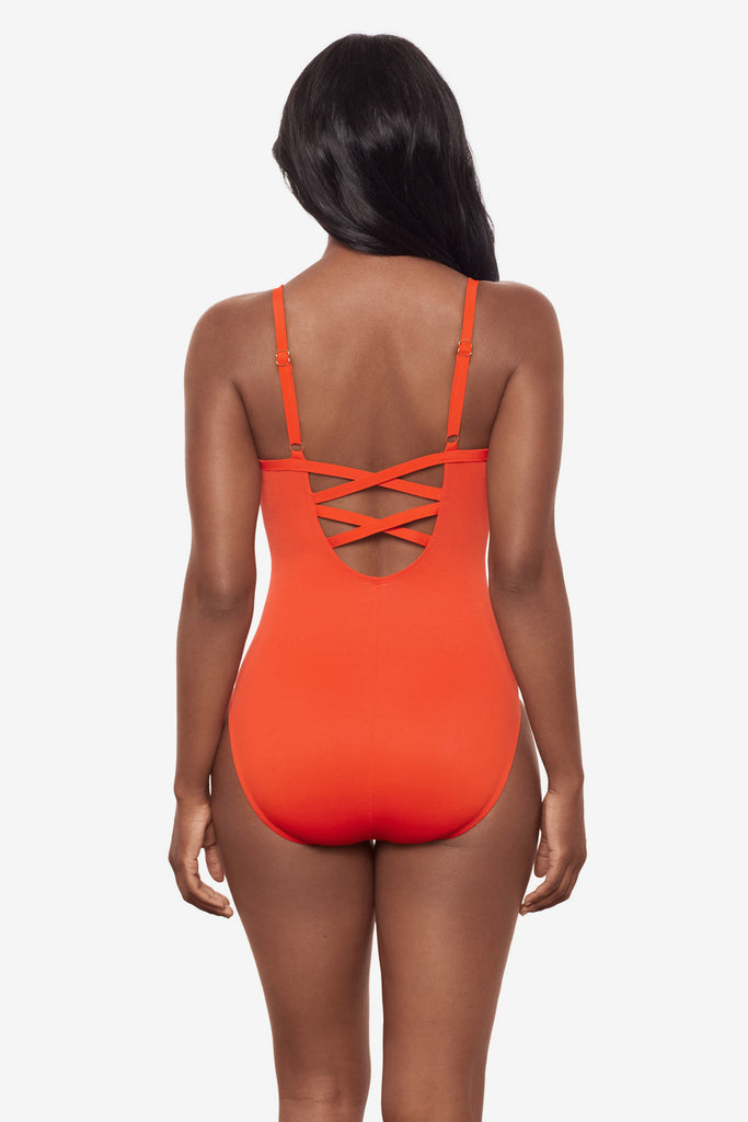 Woman turned away wearing an orange one-piece swimsuit with a lace back