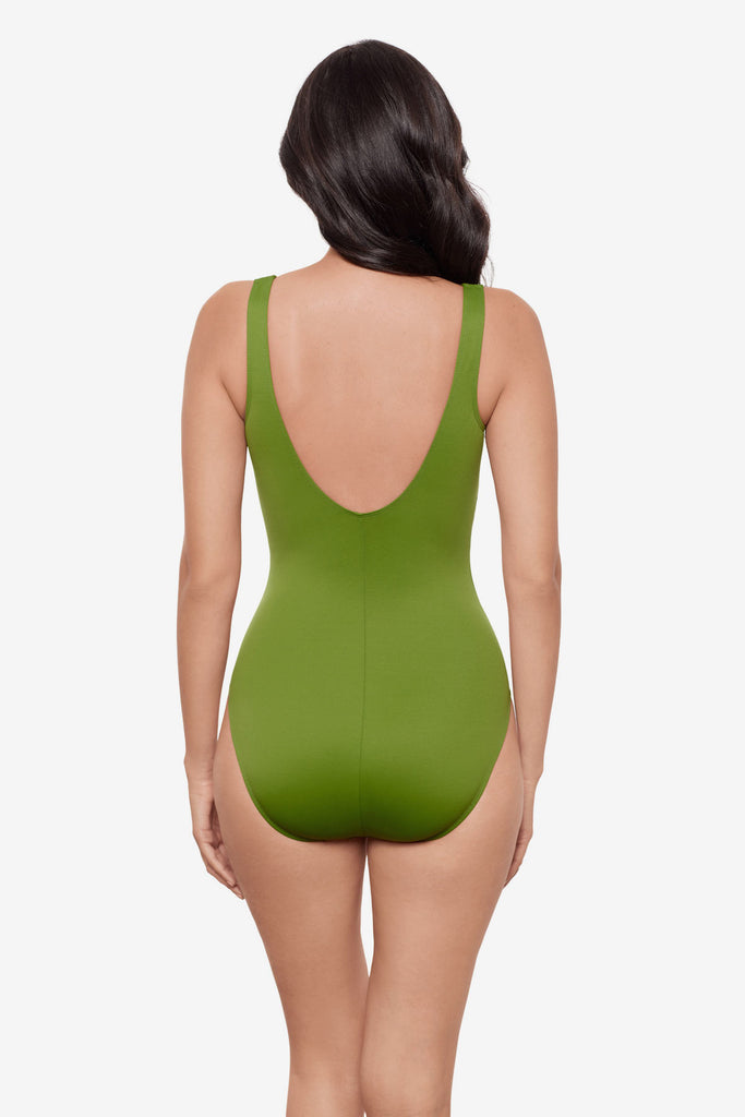 Woman turned away wearing a bright green one-piece swimsuit 