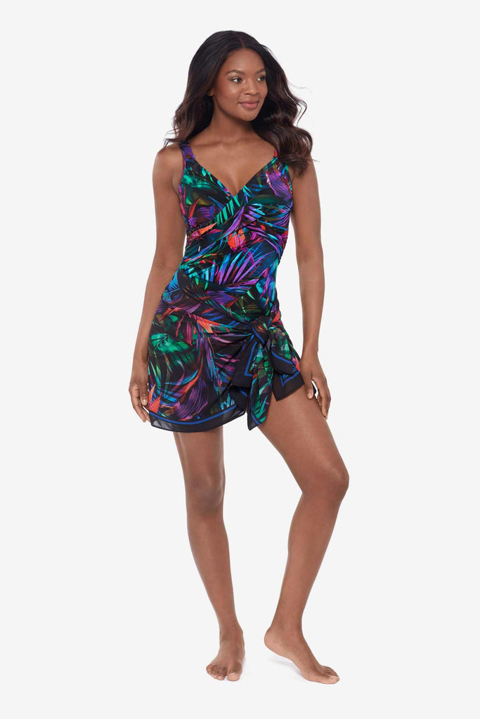 Woman wearing a cover up tied at the waist with a bright neon palm leaf pattern