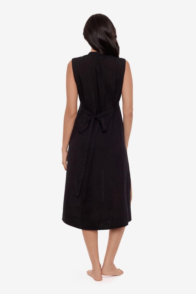 Woman turned away wearing a black swim dress cover up