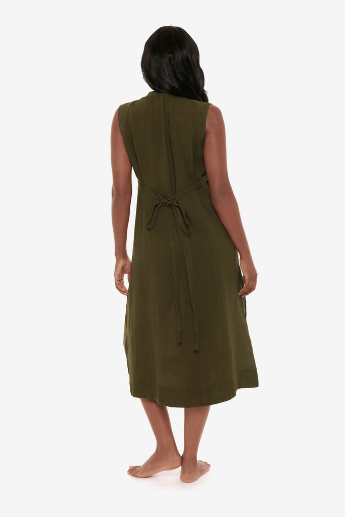 Woman faced away wearing a dark green swim dress cover up
