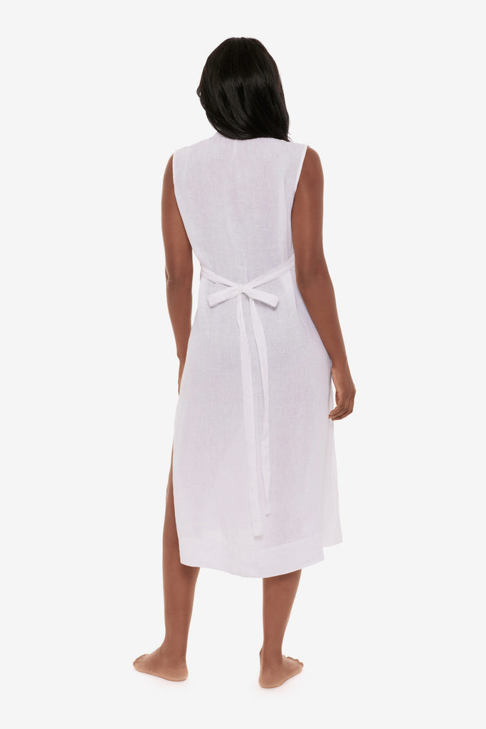 Woman turned away wearing a white swim dress cover up