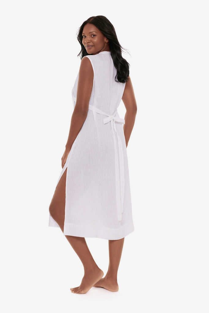 Woman turned left wearing a white swim dress cover up