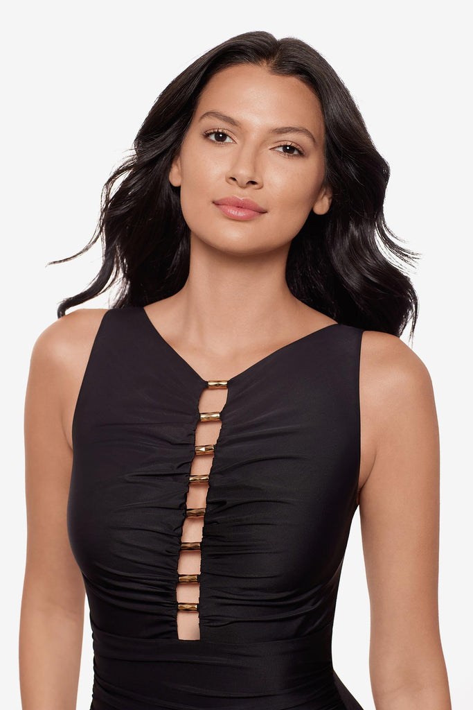 Woman wearing a black one-piece swimsuit with ruching on the front