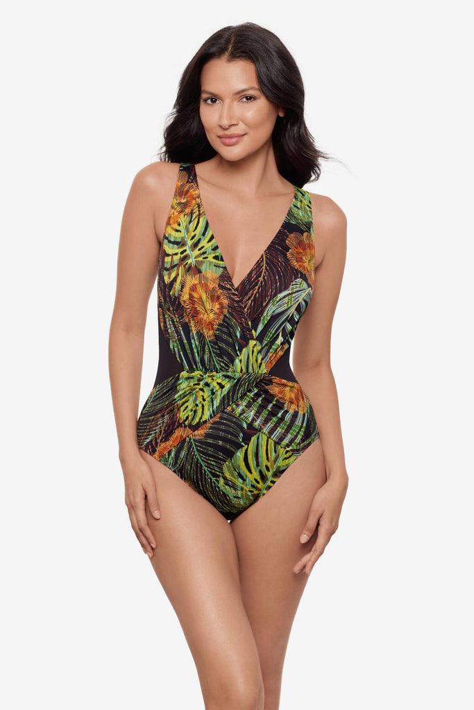 Woman wearing a multicolored palm leaf print one-piece swimsuit with a V  neckline