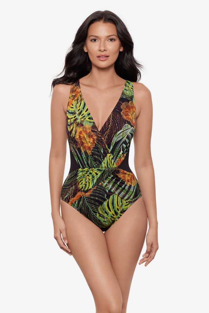 Woman wearing a multicolored palm leaf print one-piece swimsuit with a V  neckline