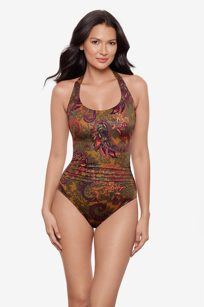 Woman wearing a halter one-piece swimsuit with brown paisley print
