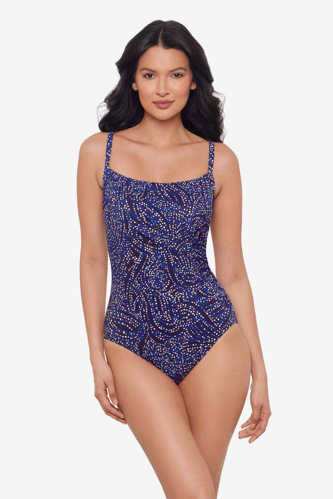 Woman wearing a one-piece multicolored swimsuit with abstract dots
