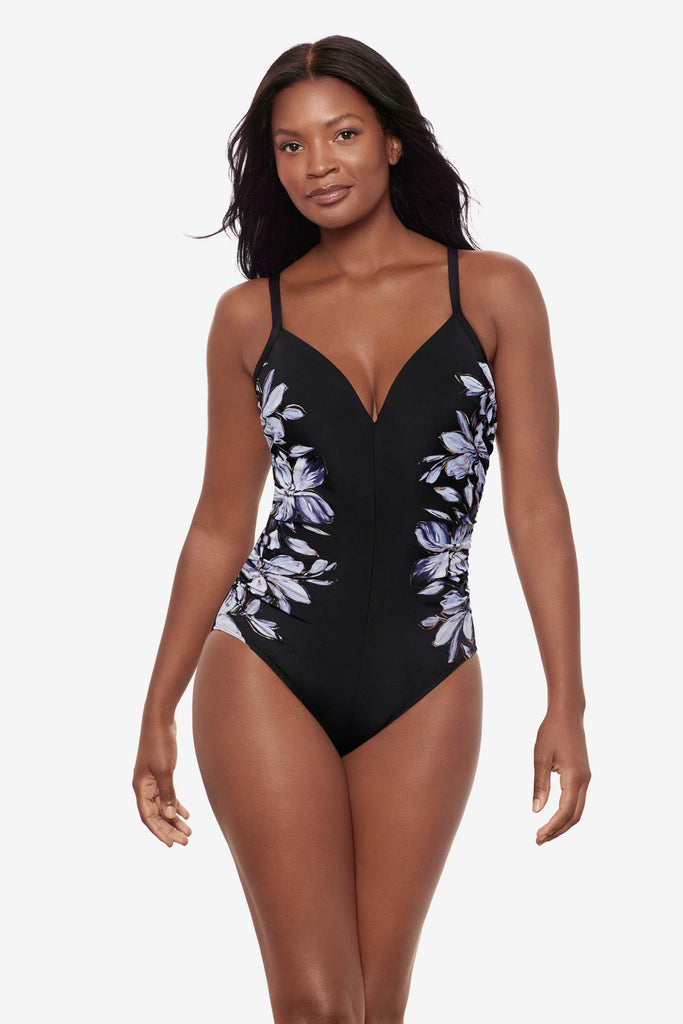 Woman wearing a black and white floral printed one-piece swimsuit with the design on each side