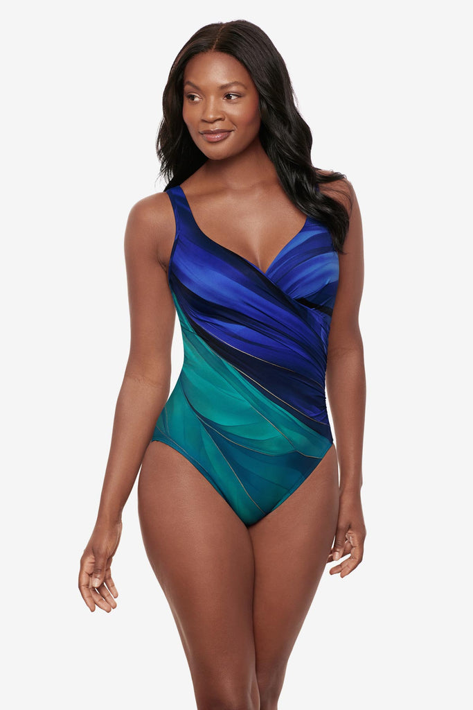 Woman wearing a multi-blue one-piece swimsuit with gold details