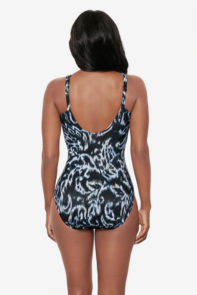 Woman turned away wearing a black and white abstract printed one-piece swimsuit