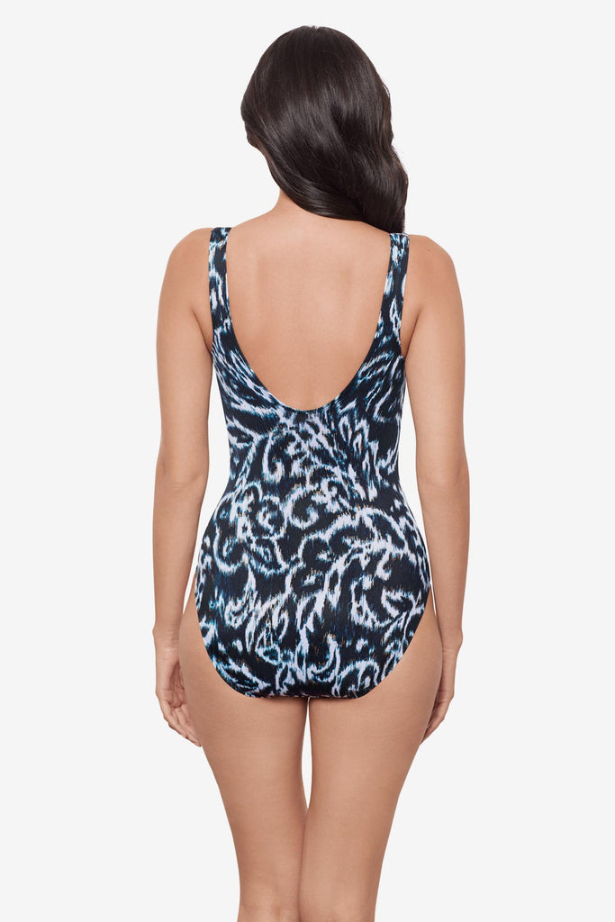 Woman turned away wearing a black and white abstract printed V neck one-piece swimsuit