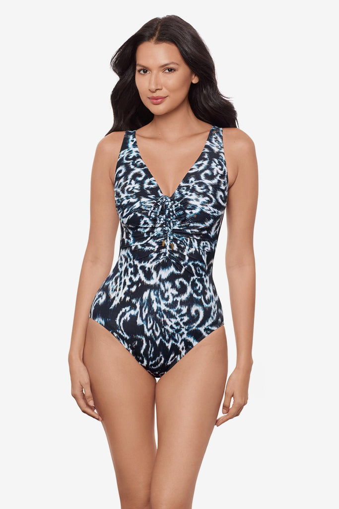 Woman wearing a black and white abstract printed V neck one-piece swimsuit