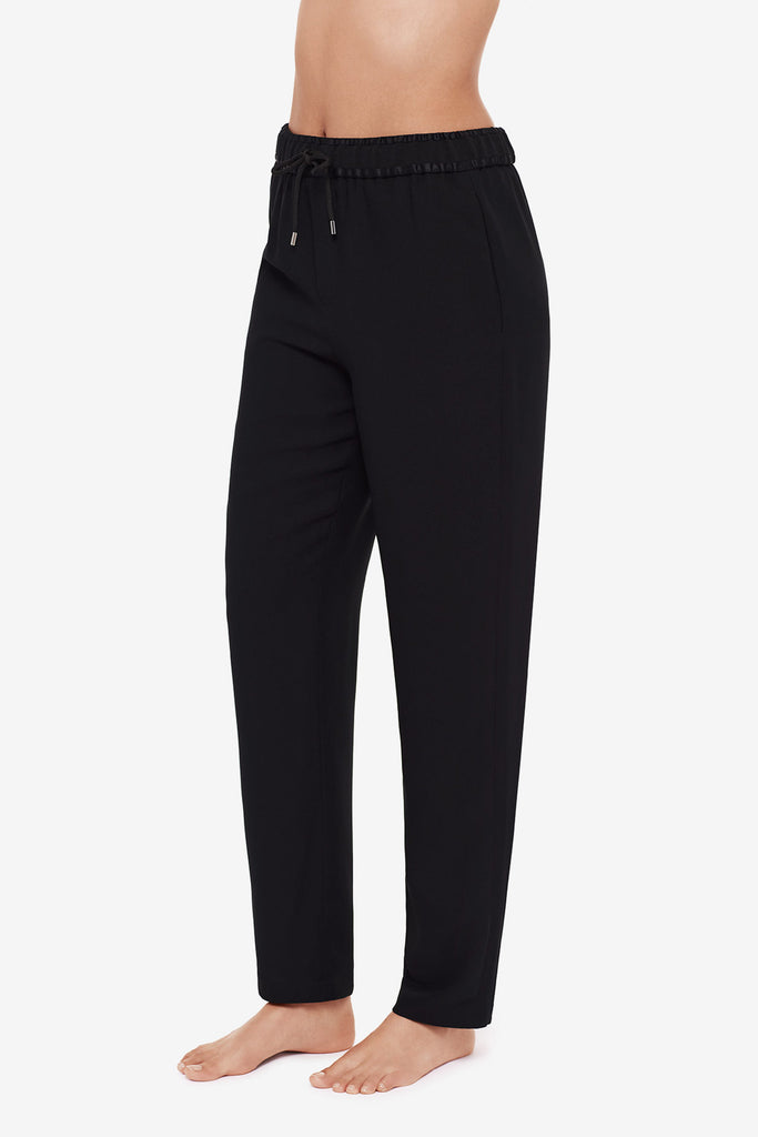 Close up of woman's legs in black jogger pants turned left 