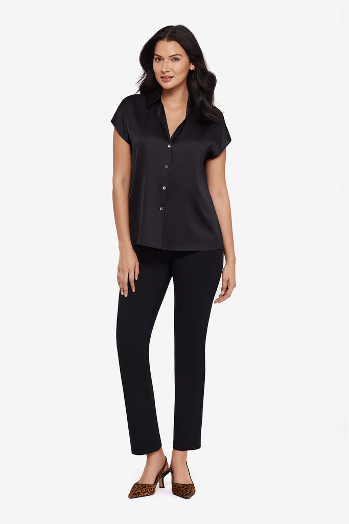 Woman wearing a black blouse with matching black slim fit pants