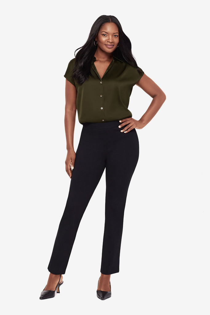 Woman wearing a green button-down blouse with short sleeves and black dress pants
