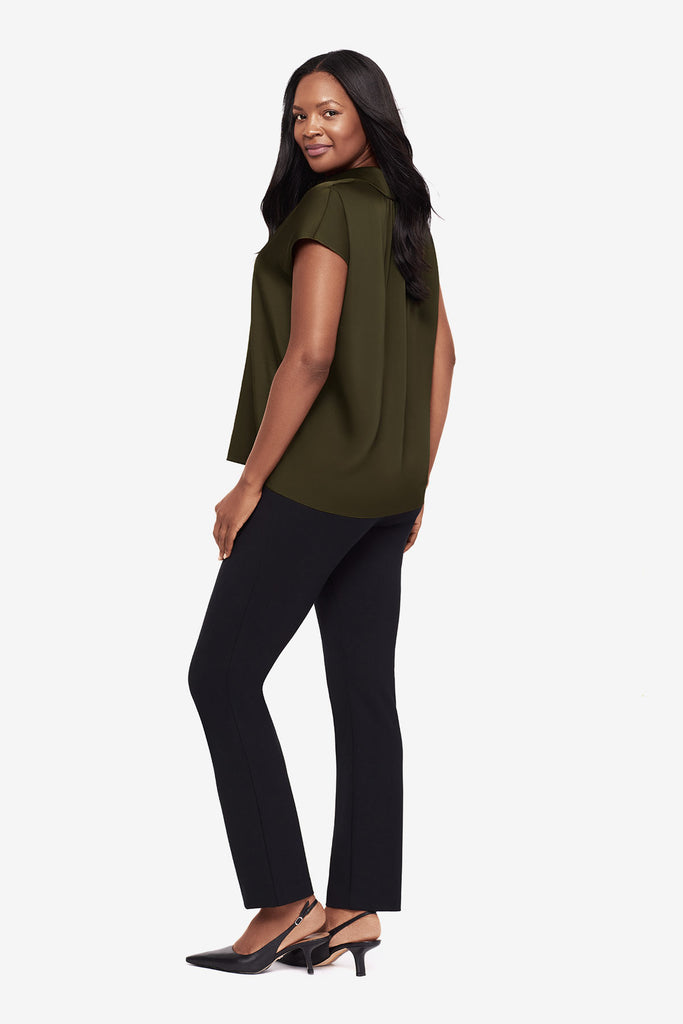 Woman turned left wearing a green button-down blouse with short sleeves and black dress pants