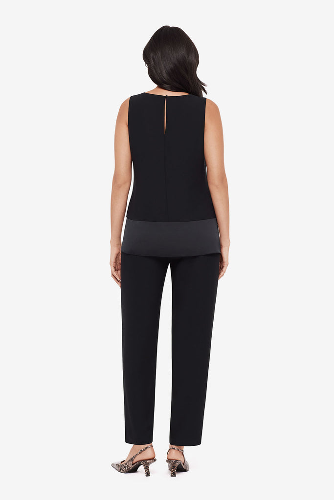 Woman turned away wearing a black layered tunic top with matching jogger pants