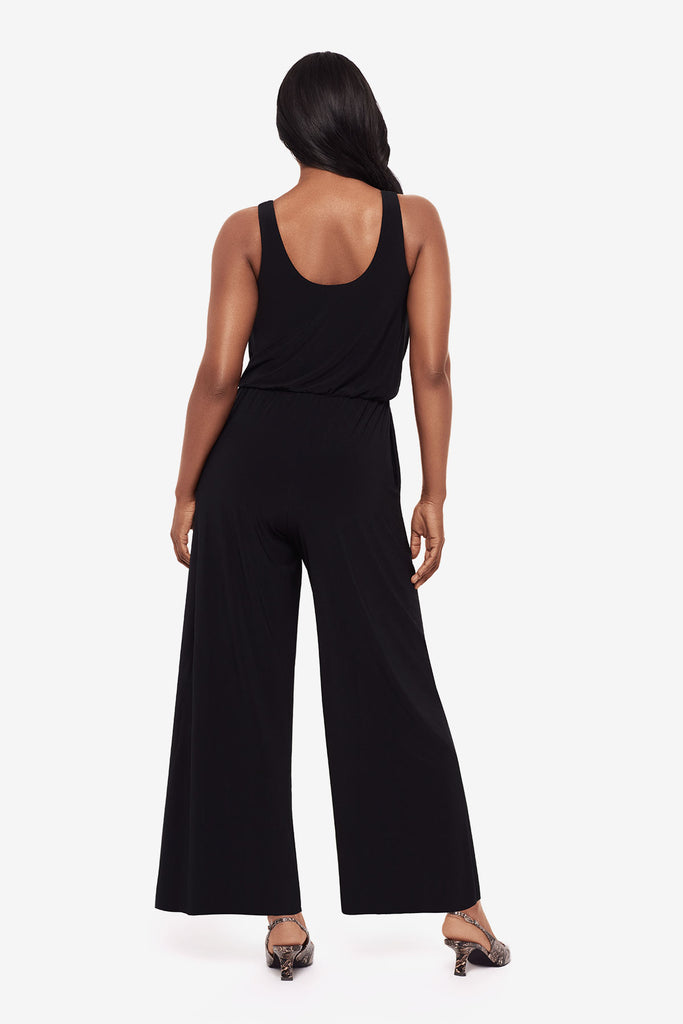 Woman turned away wearing an all black jumpsuit