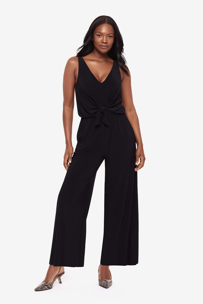 Woman wearing an all black jumpsuit with a v-neckline