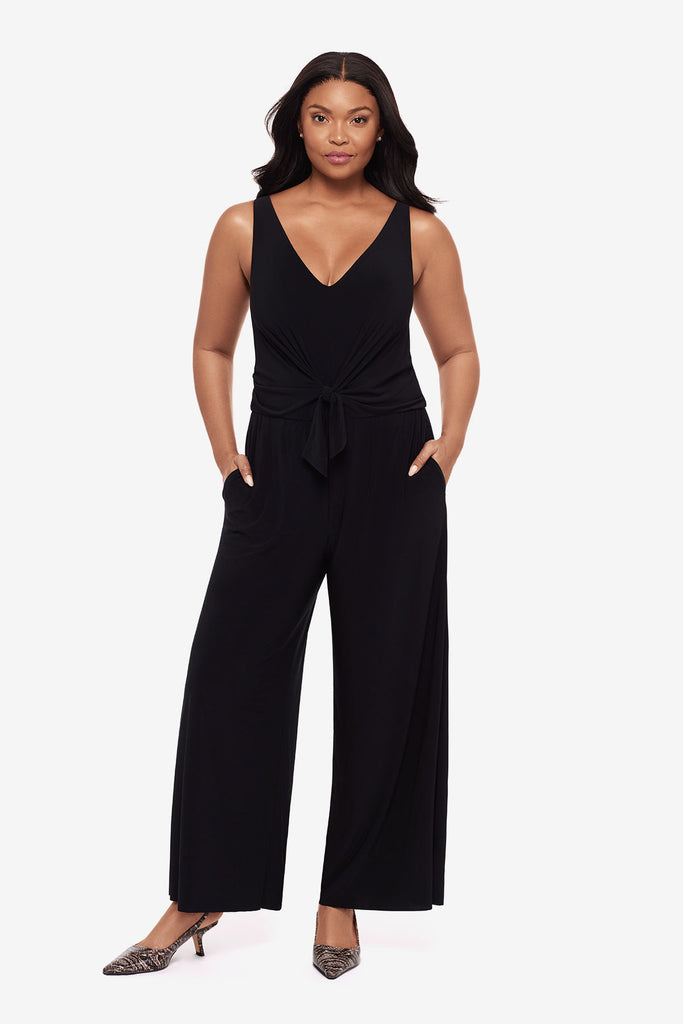 Woman wearing an all black jumpsuit with a v-neckline