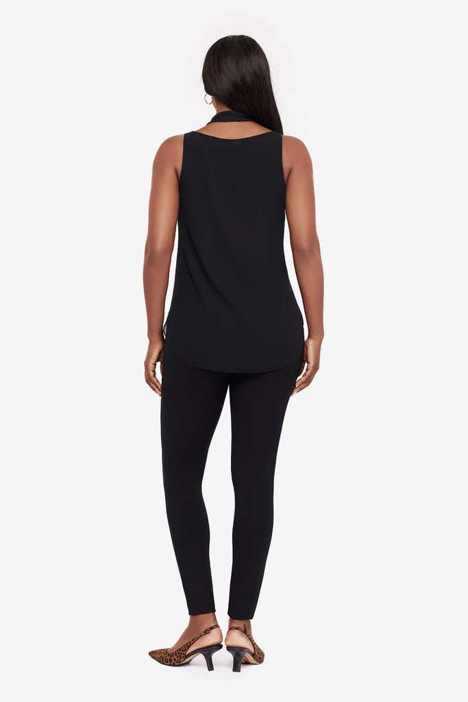 Woman turned away wearing a black layered tunic blouse with matching leggings