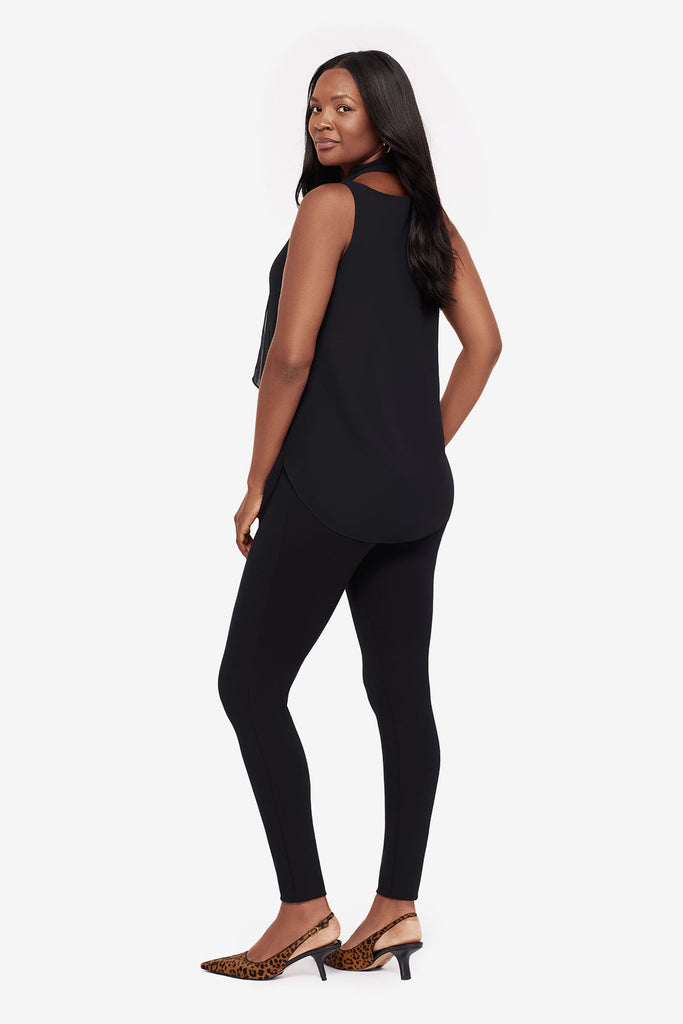 Woman turned left wearing a black layered tunic blouse with matching leggings