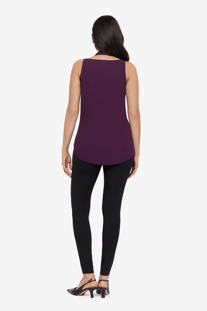 Woman turned away wearing a plum-colored tunic blouse with black leggings