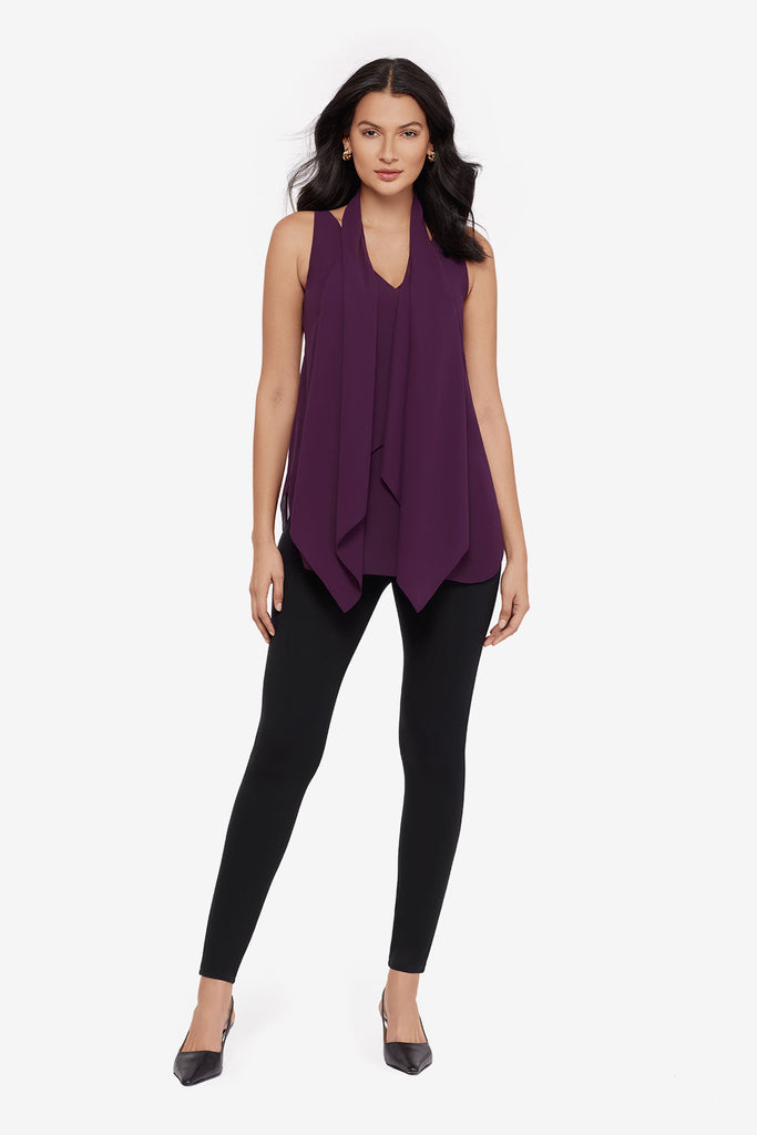 Woman wearing a plum-colored tunic blouse with black leggings