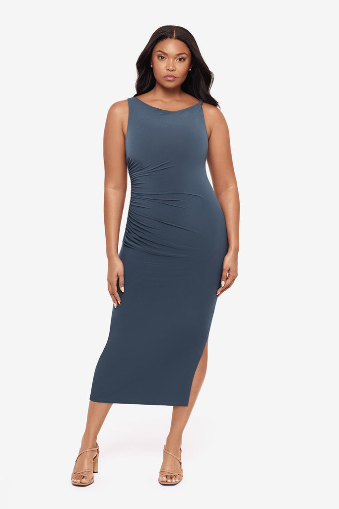 Woman wearing a slate grey maxi dress with ruching on the side