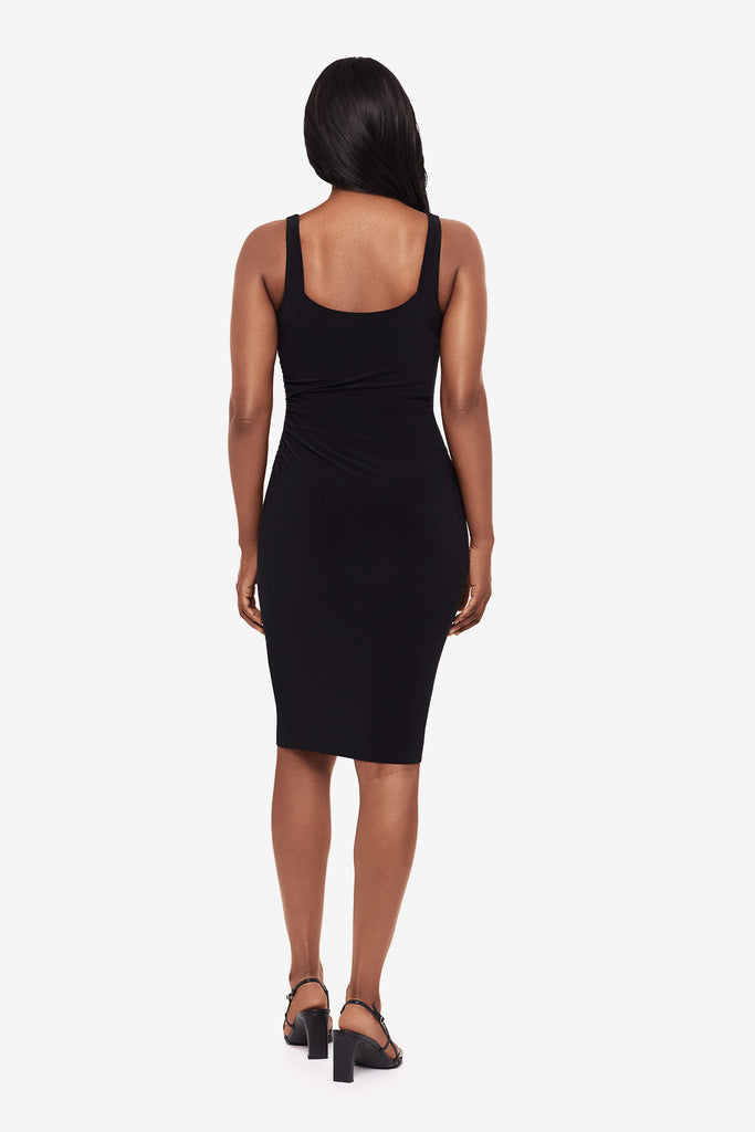 Woman turned away wearing a black midi dress 
