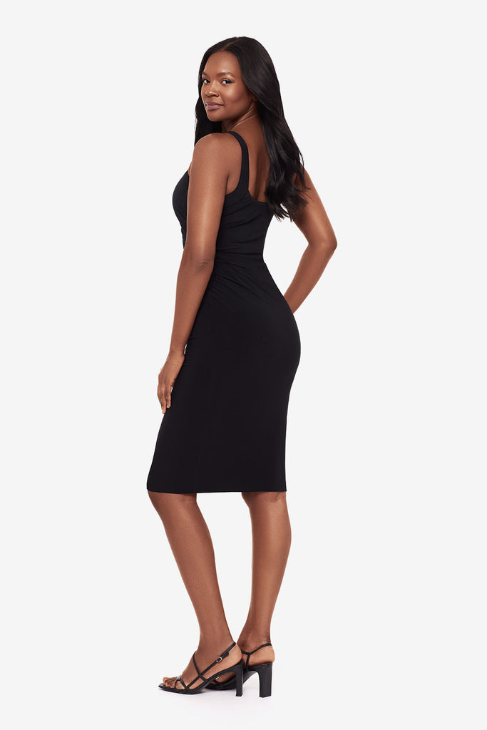 Woman turned left wearing a black midi dress with a square neckline