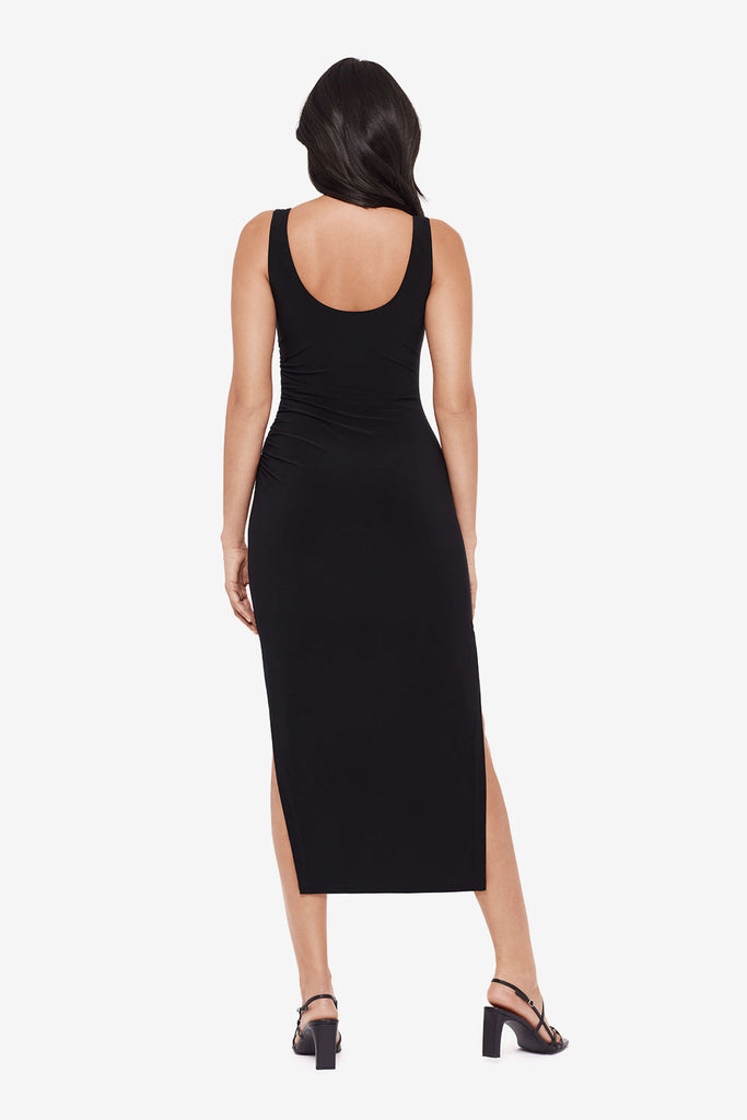 Woman turned away wearing a black maxi dress with slits on each side 