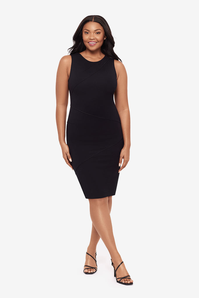 Woman wearing a black knee length dress with a scoop neck
