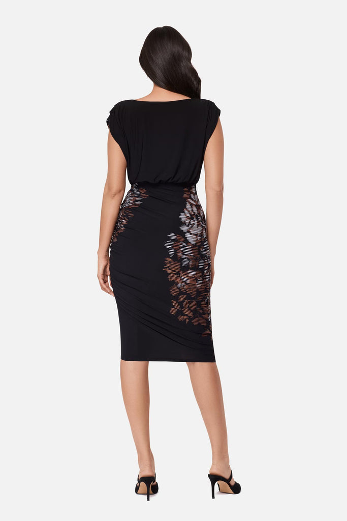 Woman turned away wearing a black dress with a floral print throughout