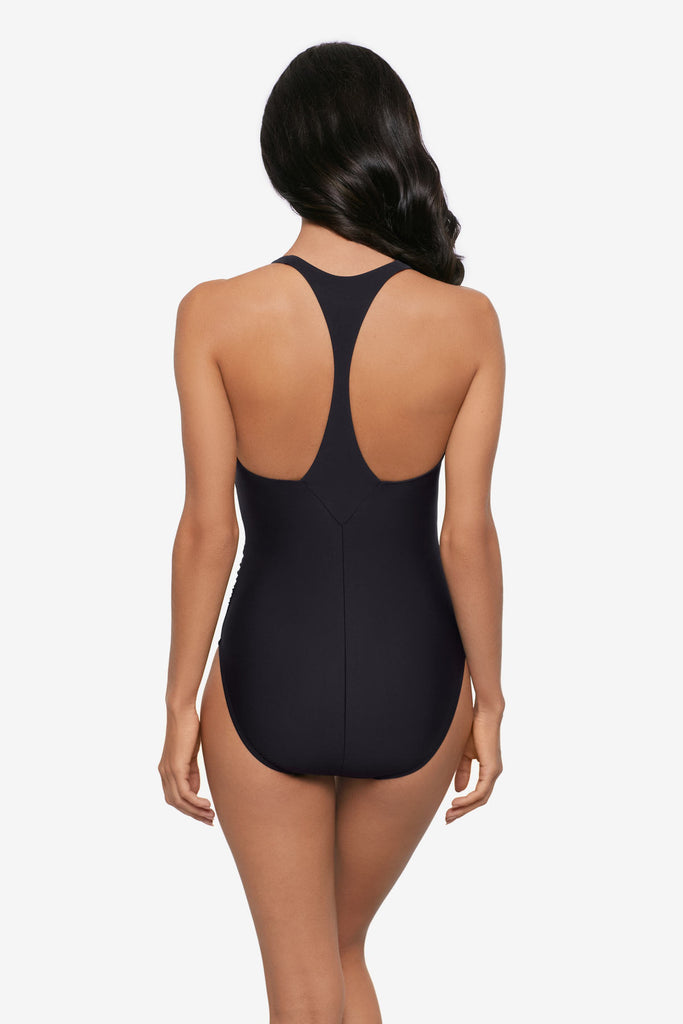 Woman wearing a black one-piece swimsuit with a T back