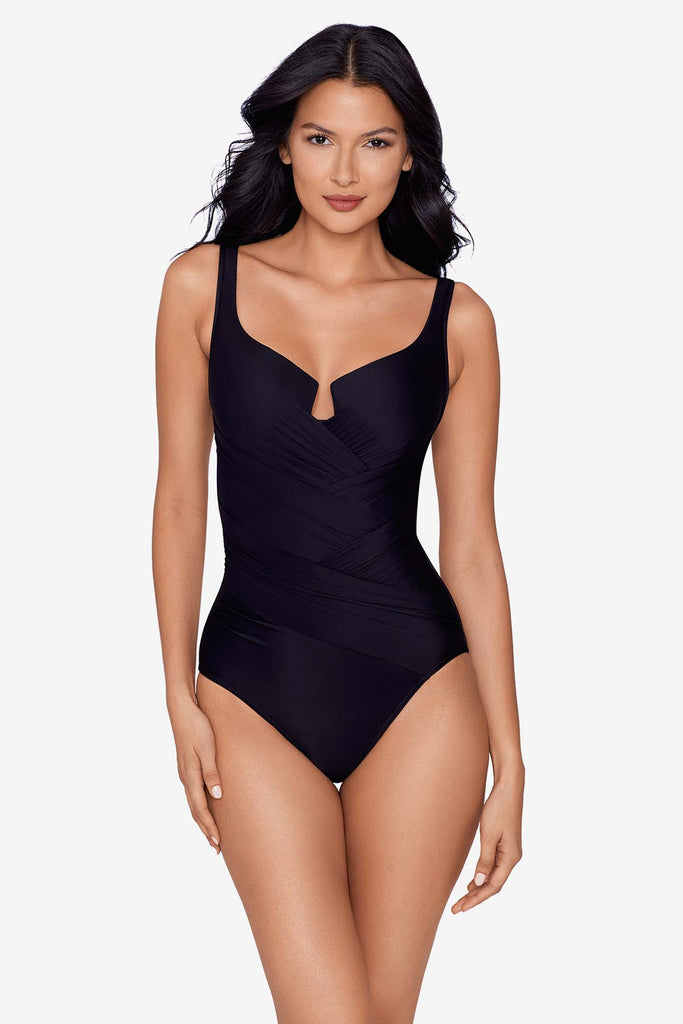 A slender girl in a one piece swim suit.
