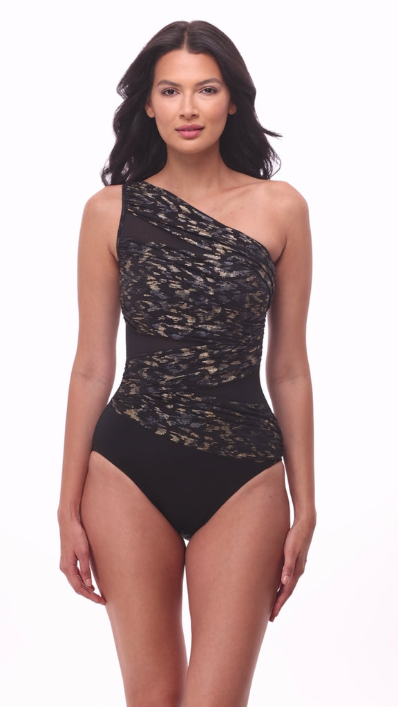 Woman wearing a one shoulder sparkly black one-piece swimsuit