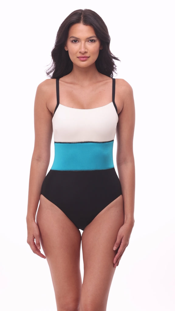 Woman wearing a white, blue and black color block one-piece swimsuit
