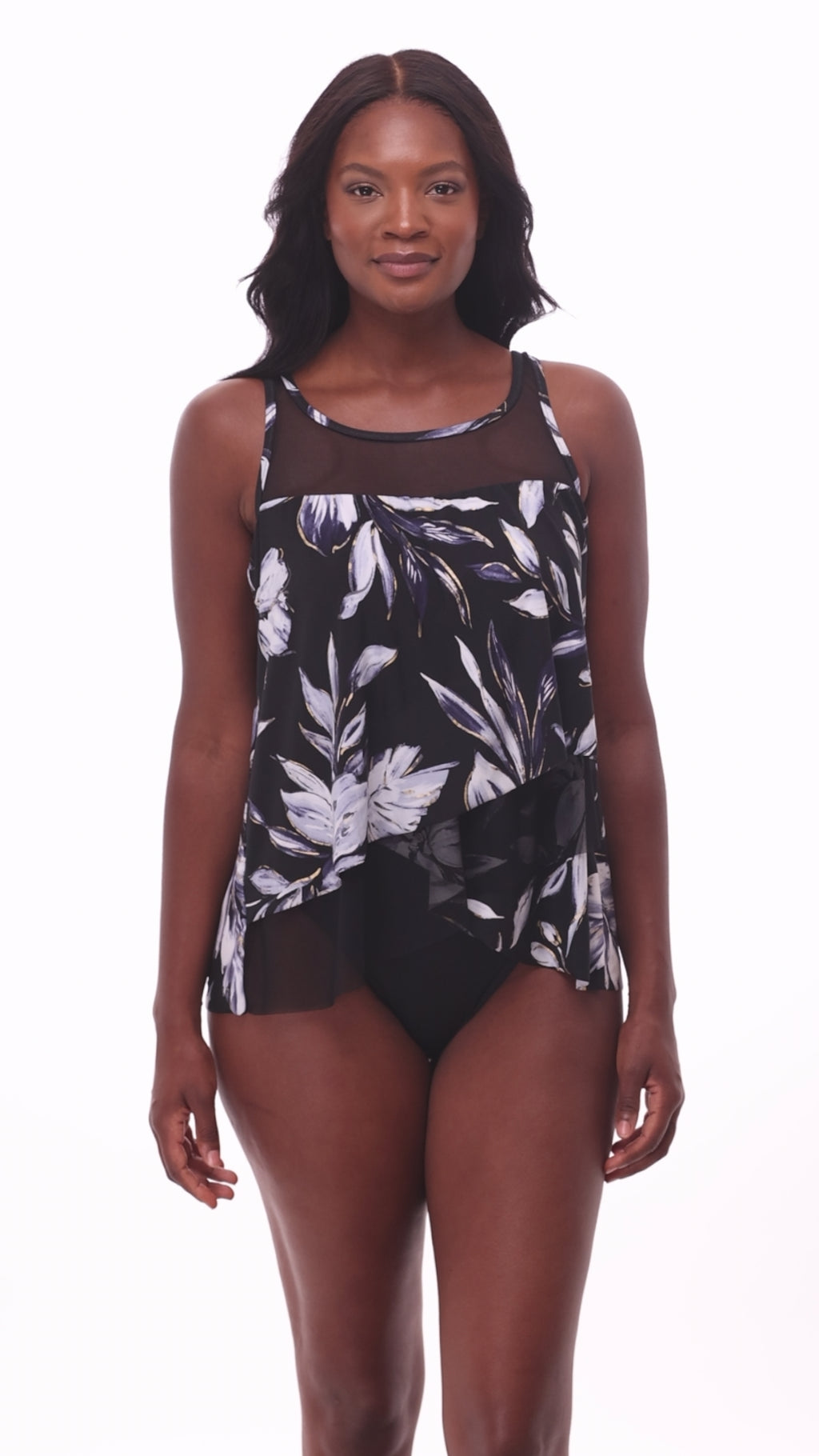 Woman wearing a black and white floral printed tankini top with mesh throughout