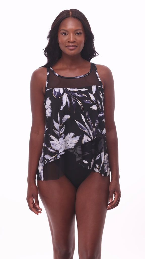 Woman wearing a black and white floral printed tankini top with mesh throughout
