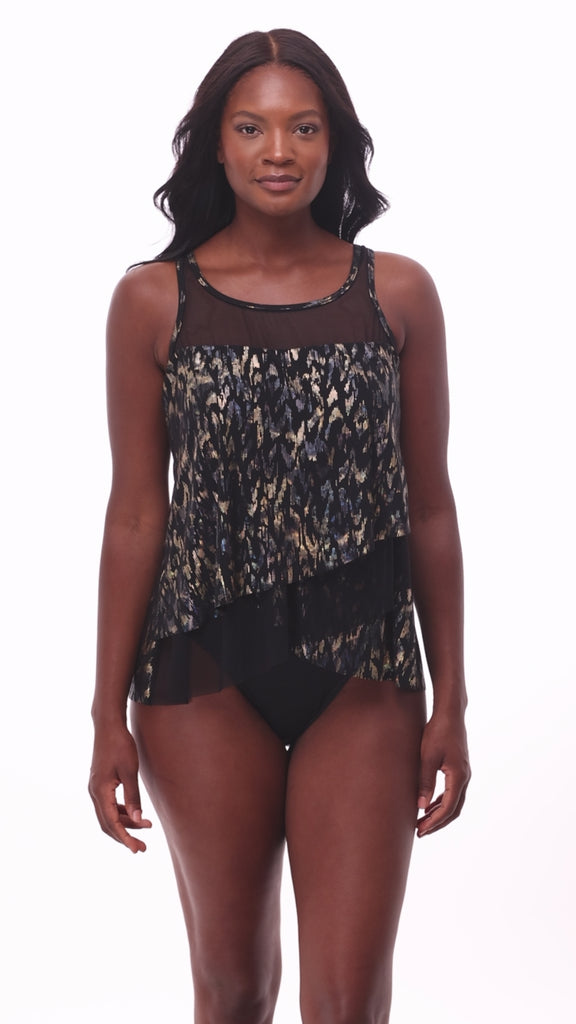 Woman wearing a black sparkly tankini top with mesh cutouts throughout