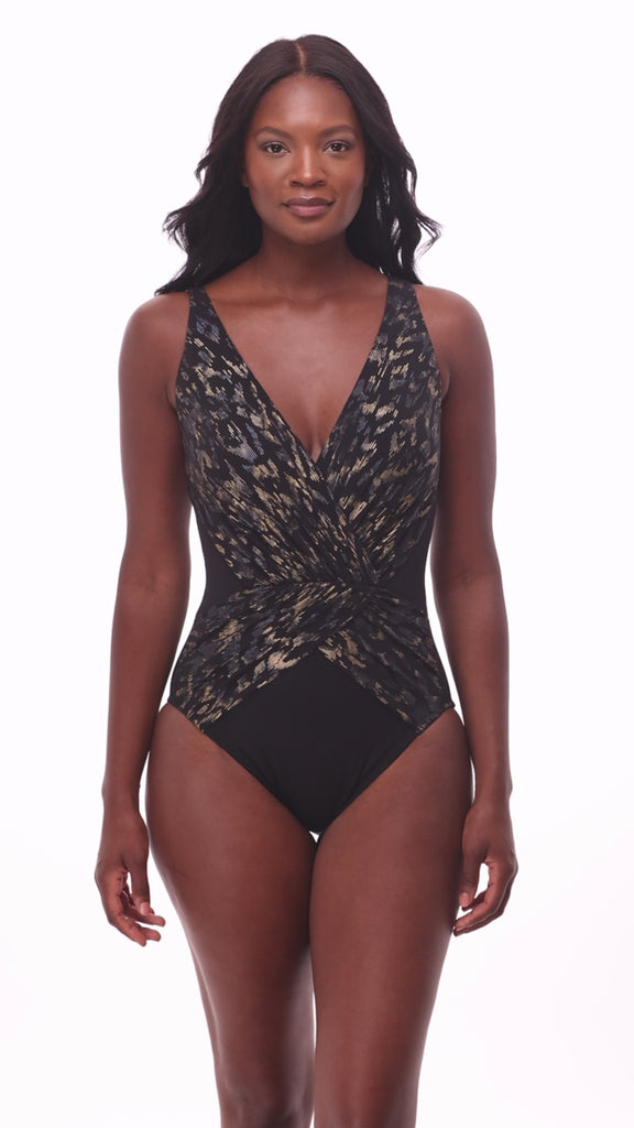 Woman wearing a sparkly black one-piece swimsuit with a V neckline