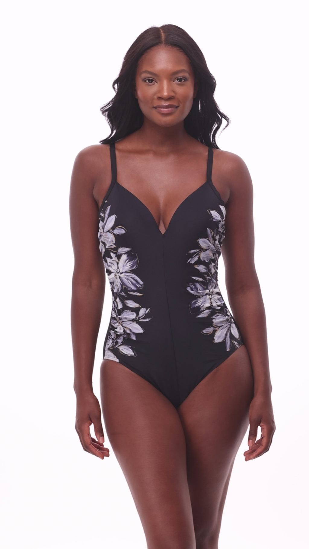 Woman wearing a black and white floral printed one-piece swimsuit with the design on each side