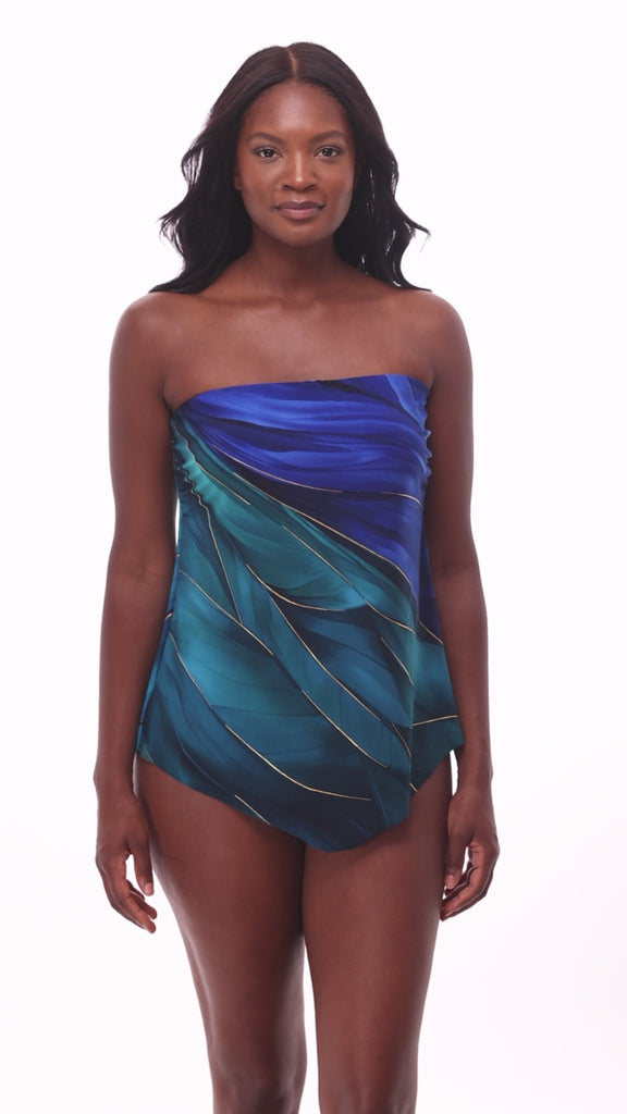 Woman wearing a multi-blue bandeau tankini top with gold detail