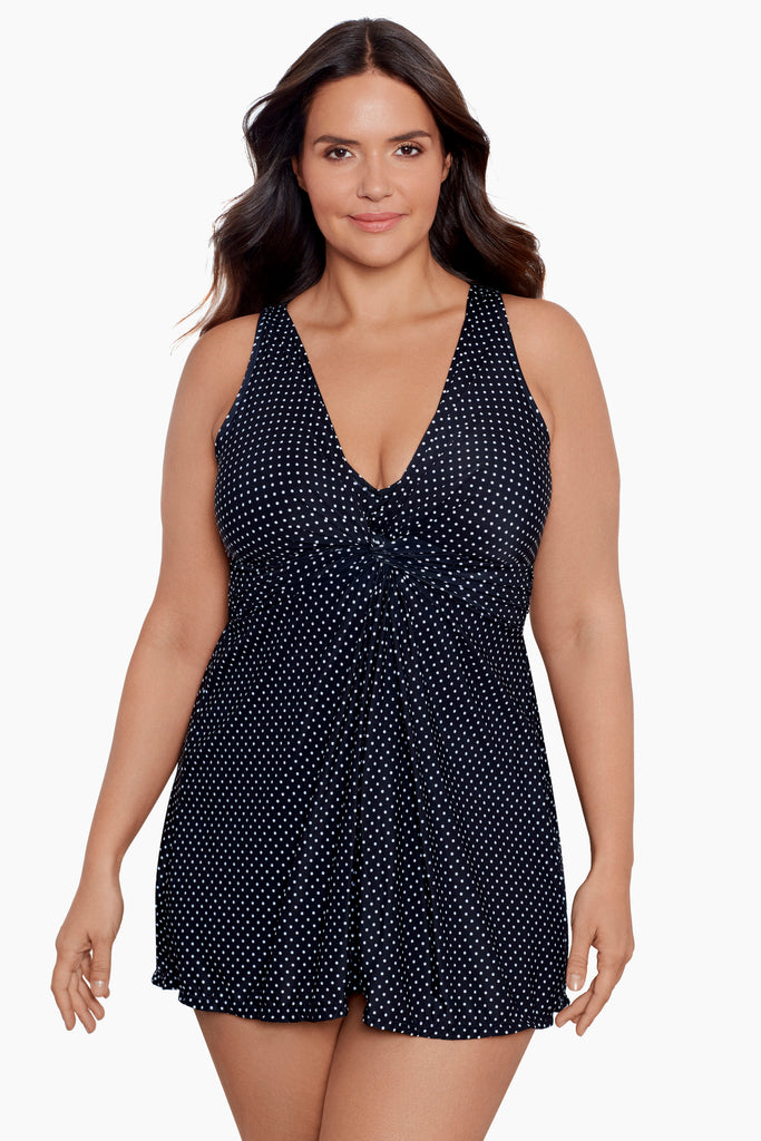 A stylish woman wearing a black swim suit with white polka dots.