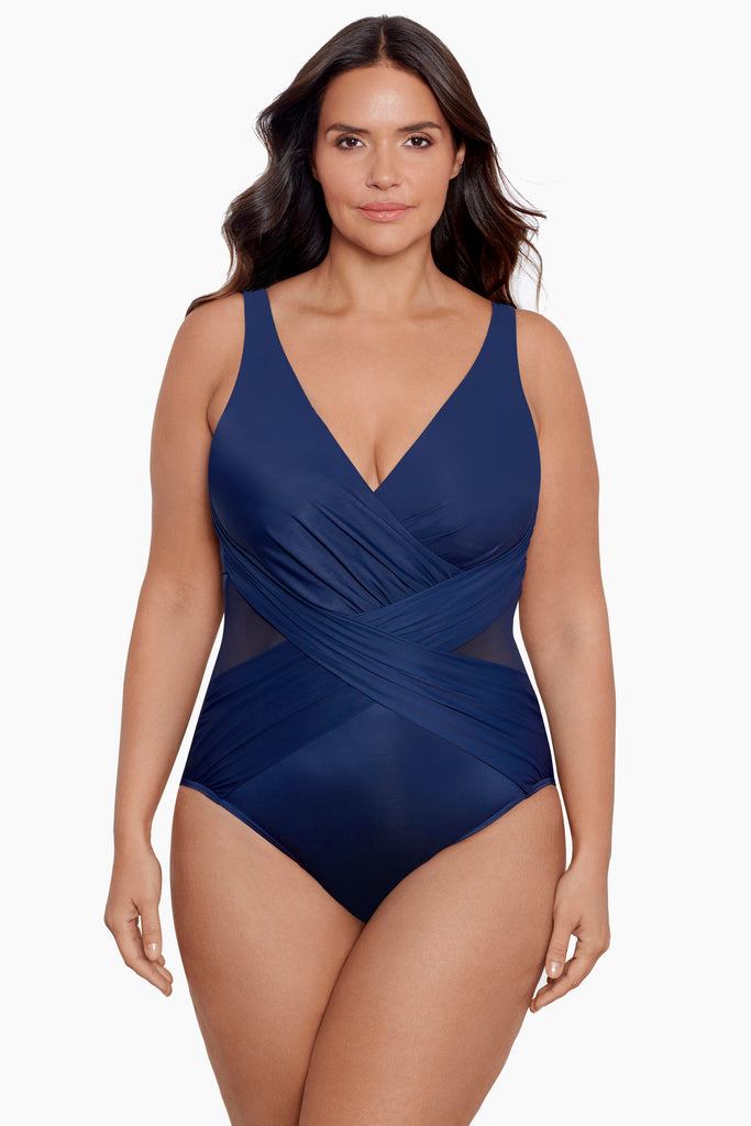 A woman wearing a plus size one piece swim suit.
